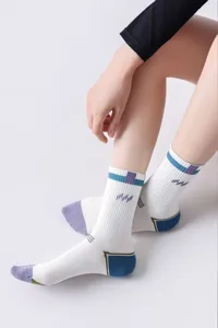 Primer plano de calcetines deportivos de compresión blancos con rayas y talones de color.