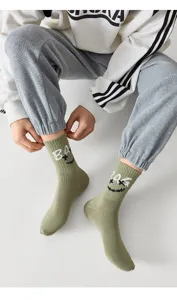 Chaussettes mi-hautes en coton vert olive avec visage souriant tissé pour un style tendance.