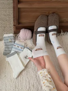 Gros plan détaillé de chaussettes mi-hautes brodées d'ours avec style rétro cosy.