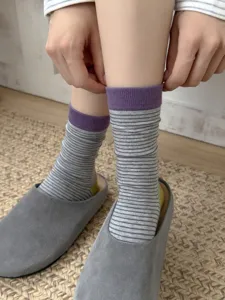 Detailed shot of retro striped women socks, mid-calf length with contrast purple cuffs.