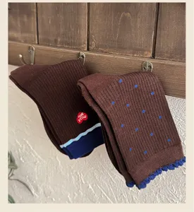 Gros plan détail de chaussettes tricotées avec broderie cœur et jolis motifs à pois mignons.