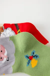 Nahaufnahme Detail von weihnachtlichen Socken mit Weihnachtsmann und Stechpalme Strickmuster.