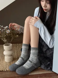 Grey Fair Isle patterned mid-tube women socks with vintage snowflake design, detail view.