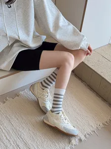 Detail shot of stylish Japanese striped split toe socks paired with vintage sneakers.