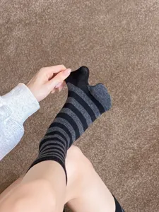 Close-up detail of women black and white striped split-toe socks showing toe structure.