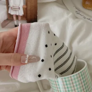 Detailaufnahme von süßen japanischen Polka-Dot-Socken mit Streifen und pinkem Rollbund.