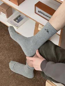Men's grey mid-tube cotton socks with stylish mountain embroidery and ribbed knit detail.
