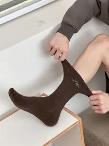 Detail view of brown men's mid-calf cotton socks featuring a stylish snow mountain embroidery.