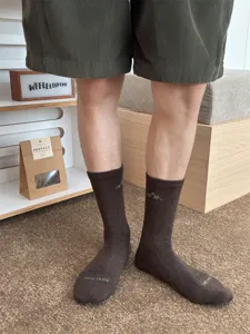Detail view of brown crew socks featuring mountain embroidery and comfortable fabric for daily wear.