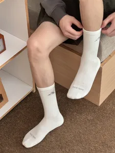 Detail view of men's white mid-calf cotton socks featuring snow mountain logo and text print.