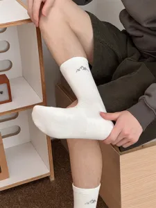 Detailed view of men's white cotton mid-calf socks featuring a trendy mountain design for street wear.