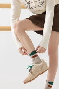 Close-up detail of cute cartoon crocodile pattern cotton mid-tube women socks, comfortable wear.