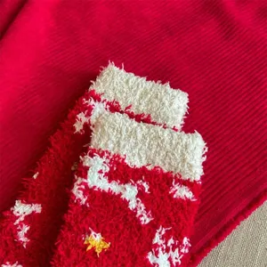Primo piano di accoglienti calzini natalizi in pile rosso con motivi, calda trama invernale.