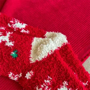 Dettaglio calzino di Natale in pile corallo, texture morbida con fiocco e alce festivi.