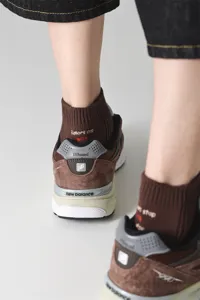 Detailed view of men brown cotton socks with ankle embroidery lettering lifestyle shot
