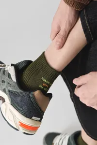 Detail view of men's green cotton crew socks featuring stylish embroidered letter design.