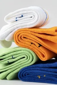 Gedetailleerd aanzicht van modieuze heren middelhoge sportsokken in wit, oranje, groen en blauw.