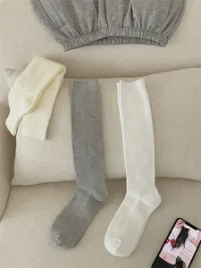 Detail shot of ribbed long socks in soft knit fabric, featuring cozy solid colors for autumn.