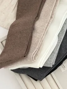 Nahaufnahme von weichen Strick-Stulpen in neutralen Farben mit feiner Textur und Elastizität.