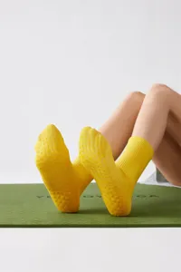 Gelbe Antirutsch-Yogasocken Detailansicht mit Grip-Noppen an der Sohle für guten Halt.