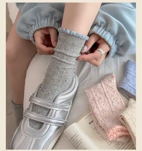 Detailed view of women knit ruffle slouch socks with flecked yarn texture, stylish autumn wear.