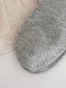 Nahaufnahme von grauen Strick-Kompressionssocken mit feiner Textur und weichem Material.