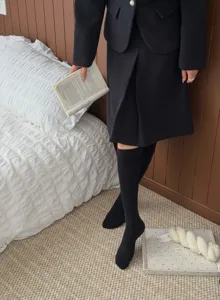 Detailansicht von schwarzen Kniestrümpfen kombiniert mit einem gemütlichen Outfit.