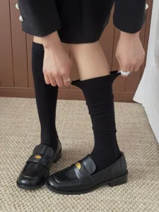 Schwarze Slouch-Socken im Detail mit weicher Strickstruktur und elastischem Tragekomfort.