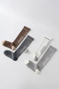 Vista dettagliata di calze alte sport compressione donna con design a righe traspirante.