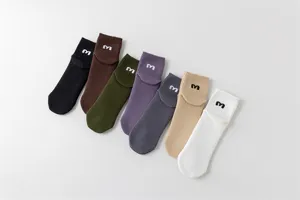 Detailaufnahme mehrfarbiger Freizeitsocken aus Baumwolle mit besticktem Buchstabenbündchen.