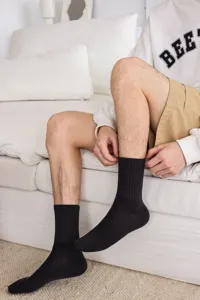 Men's black mid-tube cotton socks breathable solid color casual daily wear detailed shot.