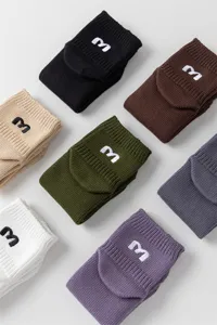 Detailaufnahme von kurzen Baumwollsocken mit gesticktem Buchstaben M in vielen Farben.