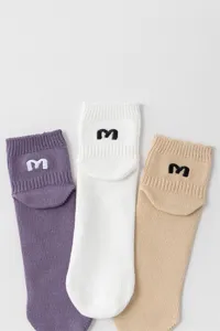 Detaillierte Nahaufnahme lässiger Baumwollsocken mit gesticktem Buchstaben M Detail.