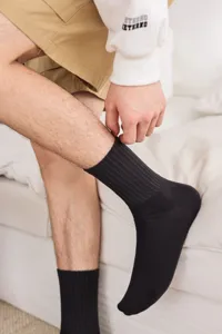 Detail shot of men's black ribbed mid-calf cotton socks, breathable and comfortable fit.