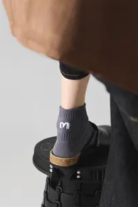 Detaillierte Nahaufnahme der grauen Herren Rippstrick Kurzsocken mit weißer Fersenstickerei.