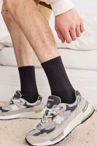 Detail view of black ribbed men's mid-calf socks worn with sneakers, breathable and comfortable daily wear.