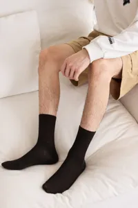 Close-up view of men's black ribbed mid-calf cotton socks, breathable and comfortable wear.
