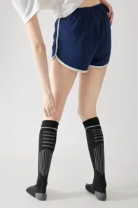 Vista dettagliata di calze a compressione sportiva con motivo a righe indossate durante l'allenamento.
