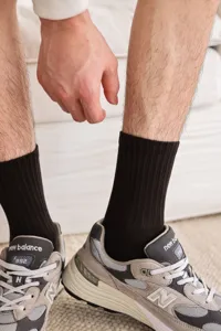 Men's ribbed crew socks in solid black, showcasing breathable texture and fit detail.