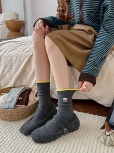 Detailansicht grauer Damen-Mittelsocken mit süßer Welpenstickerei und gelbem Bund.