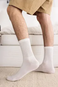 Close-up detail of men's white ribbed mid-calf cotton socks, breathable everyday wear.
