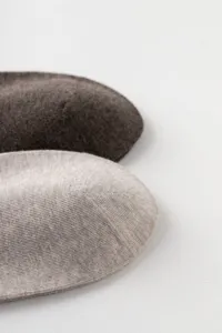 Close-up detail of soft breathable cotton knit socks in neutral beige and dark brown tones.