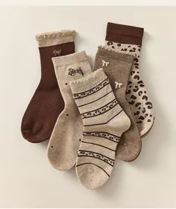 Primo piano dettagliato di calze medie da donna marroni in stile vintage con motivi leopardati.