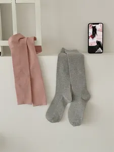 Detailed view of ribbed knit long socks in pink and grey, featuring soft fine stripes, cozy winter style.