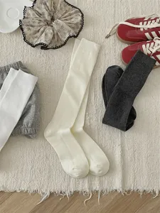 Close-up of comfortable cotton ribbed long socks with fine stripes in a cozy flat-lay setup.