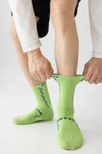 Gedetailleerd overzicht van neon groene sportieve middelhoge sokken met ademende mesh en lijnen