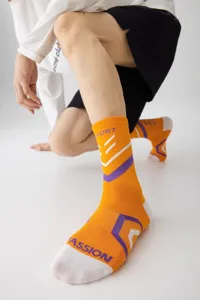 Detailaufnahme trendiger oranger-lila Sportsocken, ideal für Basketball und Laufsport im Freien.