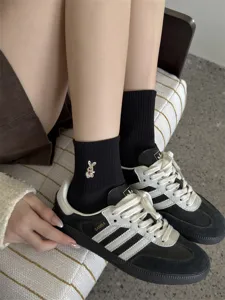 Cute black mid-calf socks featuring sweet rabbit embroidery paired with trendy casual sneakers.