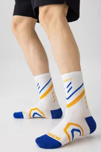 Detailaufnahme von weißen Sportsocken in Wadenlänge mit blau-gelben geometrischen Mustern.