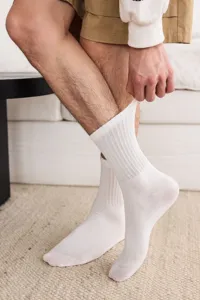 Close-up detail of pure white ribbed cotton mid-calf socks for men, comfortable breathable fabric.